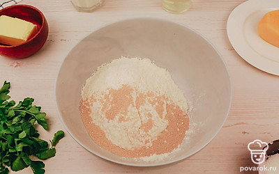 Просейте муку и добавьте к ней сухие дрожжи.