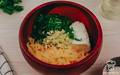 Переложите нарезанную зелень, чеснок, сыр и творог в глубокую миску.