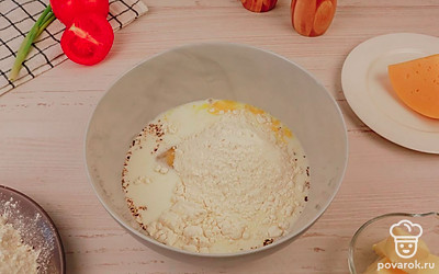 Добавьте к яйцам и молоку просеянную муку.