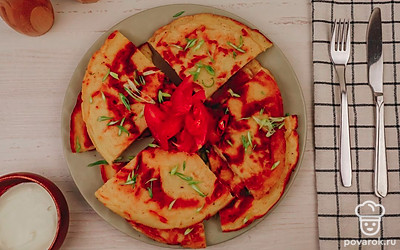 Разрежьте хачапури на порции, украсьте зеленым луком и помидором.