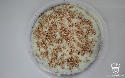 Нарежьте остывший корж на части и соберите торт, смазав каждый корж кремом. Сверху обильно посыпьте измельченными орехами. Оставьте торт на несколько часов охлаждаться и для пропитки.