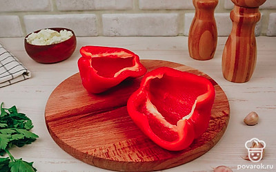 Разрежьте перец пополам и очистите от плодоножки и семян.