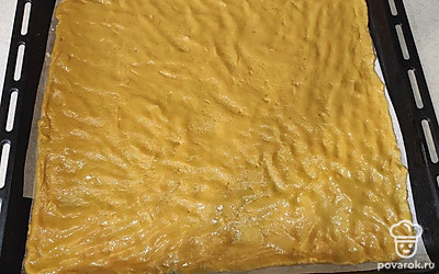 Возьмите противень, застелите его бумагой для выпечки или подложите антипригарный коврик. Полученное теста равномерно размажьте по противню.