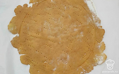 Это тесто не очень пластично, коржи легко могут порваться, если их переносить со стола на противень. Поэтому раскатывайте коржи прямо на пергаменте, подсыпая мукой. Возьмите тарелку и раскатывайте корж, выступая немного за края тарелки чуть больше его деаметра прокалываем корж вилочкой и