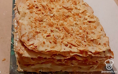 Промажьте коржи тонким слоем крема, сверху и по бокам обсыпьте торт крошками от обрезков коржей (можно раскрошить один из коржей, если обрезков мало), накройте пленкой и поставьте на торт небольшой груз (например, противень или поднос). Дайте торту пропитаться в течение 7-8 часов.