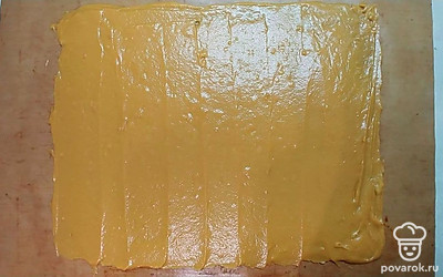 Готовое тесто разделите на 2 равные части. Выложите половину теста на противень, застеленный пергаментом или силиконовым ковриком. Лопаткой распределите тесто по всей поверхности. Выпекайте медовый корж в предварительно разогретой до 160°С духовке в течение 8 минут, до готовности коржа. Таким же образом испеките второй корж. Выпекание может занять чуть больше или меньше времени в зависимости от толщины коржа.