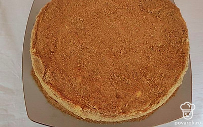 Далее все соедините и хорошо взбейте. Обмажьте поверхность торта и бока. Придайте ровную поверхность. Посыпьте присыпкой. Торт уберите на ночь в холодильник.