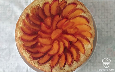 В миске смешайте молоко с сахаром и поставьте на огонь. Нагревайте до полного растворения сахара. Разведите крахмал в 100 мл молока и влейте эту смесь в горячее молоко, при этом постоянно помешивайте. Оставьте для остывания до комнатной температуры. Затем введите сметану и хорошо перемешайте. Приготовленную начинку выложить на охлажденное тесто, сверху разложите нарезанные на дольки персики. Поместите в разогретую до 180 °C духовку на 1 час. Остудить.