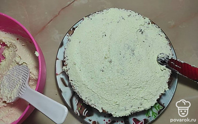 Взбейте сливочное масло до изменения цвета, введите сахарную пудру. Добавьте творог и лимонную цедру. Продолжайте взбивать. Тщательно смажьте все коржи получившимся кремом. Затем смажьте и бока. Залейте шоколадом верх торта. Бока обложите ореховой крошкой.