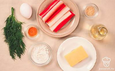 Укроп помойте и мелко нарежьте. Сыр натрите на мелкой терке. Крабовые палочки разверните. В разную посуду разбейте яйцо и насыпьте муку. Разогрейте сковороду. Совет: сложите крабовые палочки в целлофановый пакет и опустите в горячую воду на 5 минут, после этого они не будут ломаться и легко получится их развернуть.