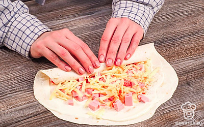 Наполните лаваш начинкой. Смажьте лаваш майонезом, равномерно выложите кусочки колбасы и тертый сыр, добавьте соль и специи по вкусу. Сверните лаваш с начинкой в крепкий рулет и порежьте его на куски толщиной 5-7 см. Лаваш с колбасой и сыром жарьте на разогретой с растительным маслом сковороде по 2-5 минут с каждой стороны.