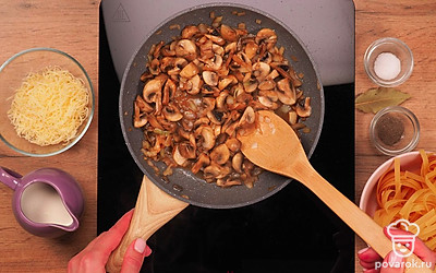 Обжарьте лук с грибами. На разогретую сковороду с маслом выложите лук, обжаривайте 1-2 минуты, затем добавьте грибы и готовьте еще 3-5 минут.