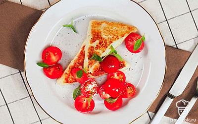 Жареный сыр сулугуни выложите на сервировочное блюдо, сверху посыпьте листиками свежей мяты или эстрагона.