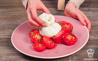 Соедините продукты. Смешайте в салатнике помидоры, чеснок и базилик. Посолите, поперчите по вкусу. Заправьте оливковым маслом, перемешайте. Выложите салат на блюдо, сверху разместите сыр в мешочке целиком.