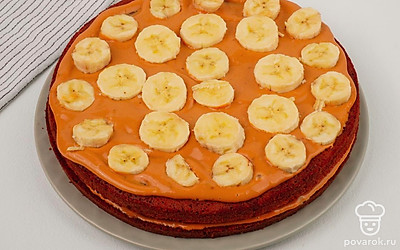 Выложите следующий корж, также смажьте кремом и выложите банан.