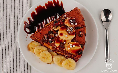 Тортик нарежьте на порции и подавайте, полив шоколадным соусом и украсив кружочками банана.