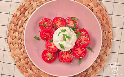 Подавайте помидоры с бурратой, украсив салат листиками свежего базилика.