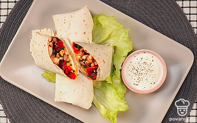 На свежие листья салата выложите готовые буррито с фасолью.