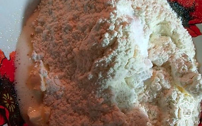 Порционно всыпайте просеянную муку и хорошо перемешивайте. В конце добавьте соду. 