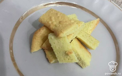 Нарежьте тонкими брусочками готовый бисквит.