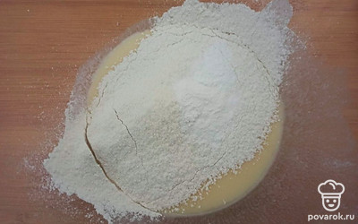 В посуду для замешивания влейте йогурт. Добавьте яйцо, сахар, разрыхлитель, соль и просейте муку.