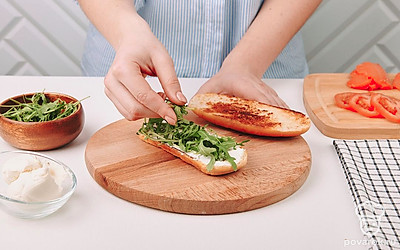 Соберите сэндвич. На булочку намажьте творожный сыр и выложите рукколу.