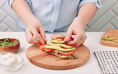 Последний слой - авокадо. Накройте начинку второй булочкой.