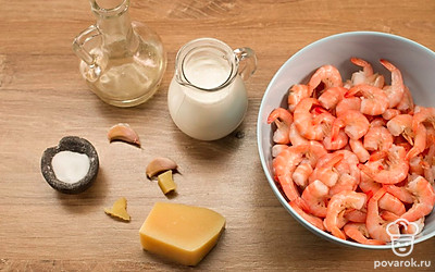 Разморозьте и очистите креветки. Очистите и измельчите чеснок. Мелко натрите сыр.