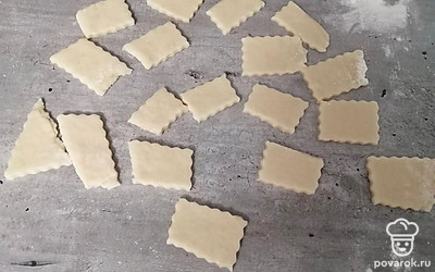 Тесто разрежьте фигурным ножом. Переложите на противень. Выпекайте в духовке 15 минут на среднем огне. 