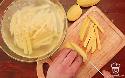 Очистите картофель и нарежьте средними брусками, затем промойте несколько раз под холодной водой и замочите на 1 час, чтобы удалить крахмал с поверхности брусков. Подготовьте фритюр или глубокий сотейник.