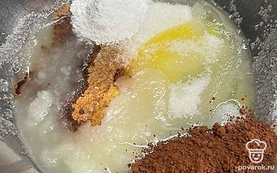 В миску добавить яйцо, сахар, какао, масло, изюм, грецкий орех. Хорошо перемешать.