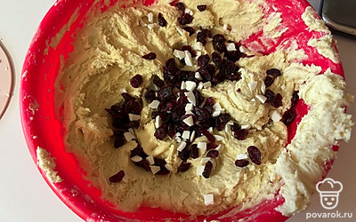 В тесто добавьте клюкву и мелко нарезанный шоколад, перемешайте.