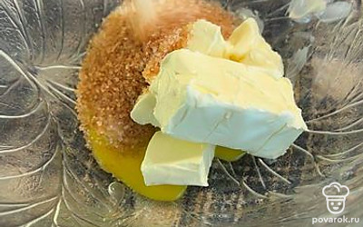 В размягченное сливочное масло всыпьте сахар, желтки и перемешайте.