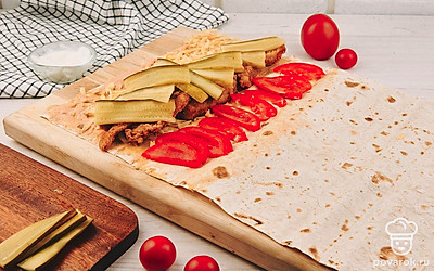 На курицу выложите омлет, а сверху овощи.