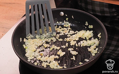 Приготовьте зажарку. Мелко нарежьте лук и чеснок. Разогрейте сковороду с маслом. Обжарьте лук и чеснок 1-2 минуты.