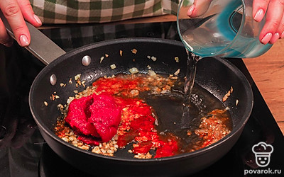 Приготовьте соус. Засыпьте в сковороду коричневый сахар и перемешайте. Когда сахар расплавится, а лук с чесноком закарамелизируются, выложите на сковороду паприку и томатную пасту. Тушите соус 1-2 минуты, постоянно помешивая.
