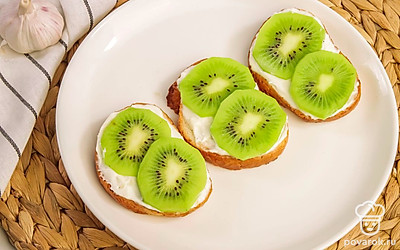 Выложите на гренки ломтики киви.