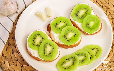 Сделайте мини канапе с киви и подайте такую закуску на праздничный стол. Добавьте в закуску ломтики обычной или пармской ветчины, отварную курицу или красную рыбу. Украсьте блюдо красным виноградом.