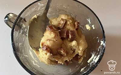 К приготовленному тесту добавьте нарезанный шоколадный батончик. Перемешайте.