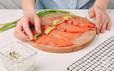 На рыбные пластики положите кусочки авокадо.