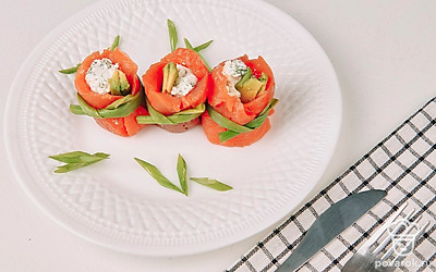 Подайте рулетики на плоской тарелке, украсив ее зеленью и кусочками авокадо. Также можно каждый рулетик поставить в тарталетку.