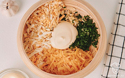 Мелко нарежьте чеснок и зелень, натрите на крупной терке сыр и яйцо. Переложите все ингредиенты в глубокую тарелку и добавьте к ним майонез.