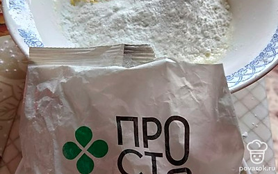 Сахар соедините с маслом комнатной температуры, хорошо взбейте миксером. Добавьте белок одного яйца, муку, крахмал, разрыхлитель, цедру. Влейте сок лимона.