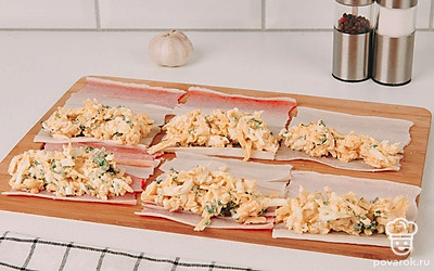 В каждую развернутую крабовую палочку положите несколько чайных ложек начинки.