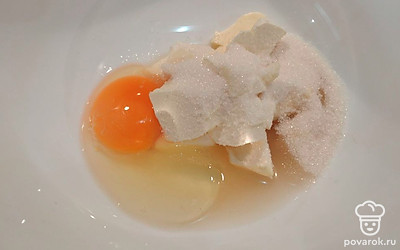 В миску положите мягкое сливочное масло, яйцо, сахар. Перемешайте. 