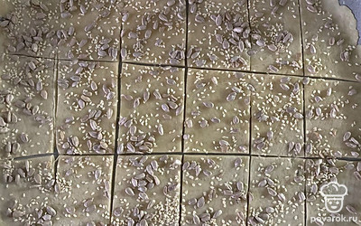 Тесто смазать яйцом и посыпать семечками. Разрезать на небольшие кусочки. Выпекать в духовке при 180 градусах до готовности.