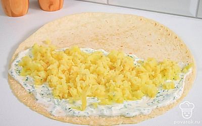 Сверху по сметане равномерно распределите тертый вареный картофель. Посолите и поперчите.