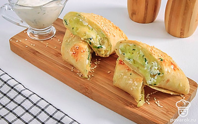 Разрежьте рулет на несколько частей. Запеченный лаваш с картофелем и сыром готов.