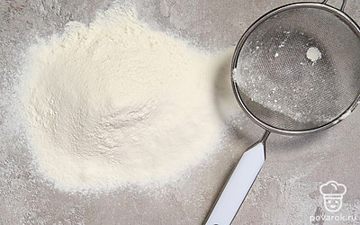 Отложите 1 ст. л. муки для работы с тестом. Всыпьте разрыхлитель в оставшуюся муку, перемешайте. Просейте муку с разрыхлителем на чистую сухую поверхность. 