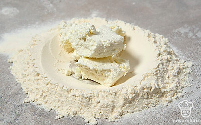 Сделайте в центре кучки муки углубление, выложите в него творог. Замесите руками плотное тесто. 